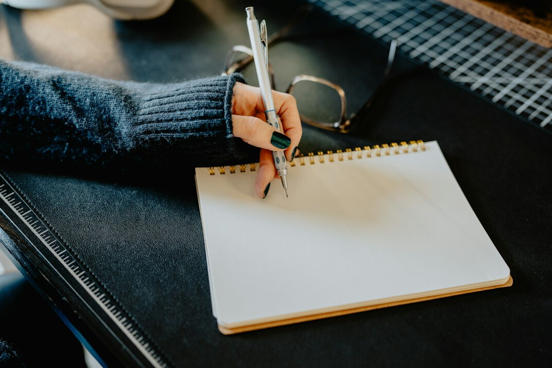 person writing in notebook